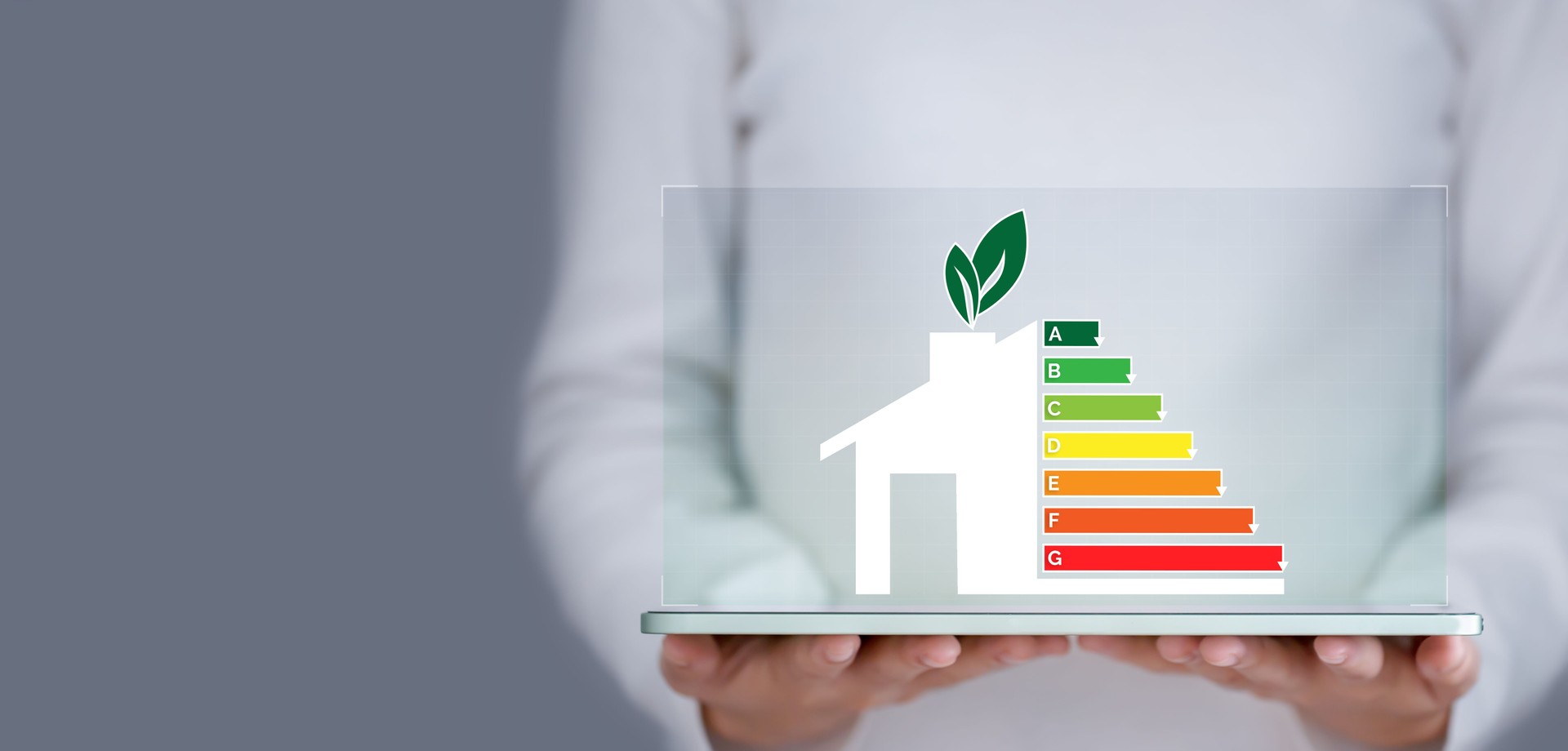 Energy efficiency and green energy concept, woman hand holding tablet and looking at house efficiency rating.